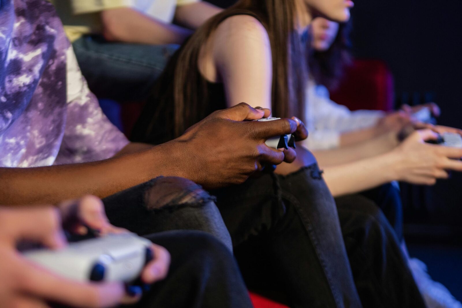 Teens playing video games with controllers, focused and engaged.